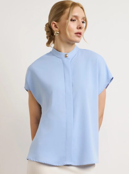 Γυναικείο πουκάμισο σχεδιασμένο με minimal αισθητική και ριχτή εφαρμογή. Διαθέτει μάο γιακά με διακριτικό διακοσμητικό κουμπί στο λαιμό. Κλείσιμο με κρυφά κουμπιά σε όλο το μήκος. Διαθέτει κοντό μανίκι. Το ύφασμα έχει απαλή υφή.