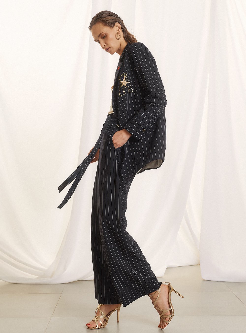 Γυναικείο ψηλόμεσο παντελόνι με ρίγες και πλαϊνές τσέπες FIGARO FASHION. Διαθέτει ζώνη ίδιου υφάσματος με διπλή αγκράφα