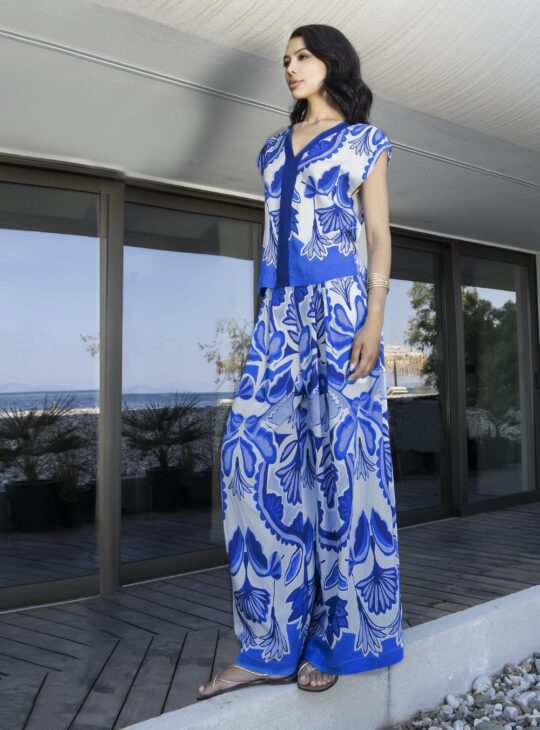 Γυναικεία παντελόνα με άσπρη βάση και μπλε print σε διάφορες αποχρώσεις του μπλε AGGEL KNITWEAR. Διαθέτει ζώνη μπλε με μεταλλική κλωστή.