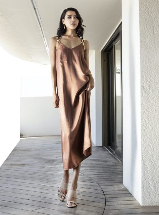 Μακρύ φόρεμα κατασκευασμένο από ανάλαφρο ύφασμα σατινέ ,με χρυσές λεπτομέρειες στις τιράντες AGGEL KNITWEAR. Σύνθεση:76%ECOVERO VISC -24%PES Χρώμα:MOCCA