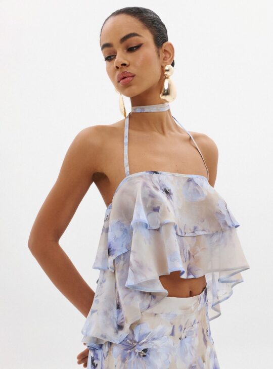 Γυναικείο top κατασκευασμένο από λεπτό ύφασμα σιφόν με διαφανές φινίρισμα ANNA SAMOUKA THEA TOP. Λεπτομέρειες με βολάν για εφέ όγκου Δέσιμο στο λαιμό με λεπτές τιράντες Cropped Ελαφρύ, λεπτό ύφασμα Ελαστική λεπτομέρεια στην πλάτη για σταθερή εφαρμογή Τύπωμα με την υπογραφή της Άννας Σαμούκα Κατασκευασμένο στην Ελλάδα