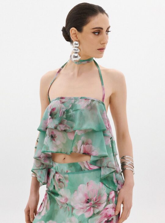 Γυναικείο top κατασκευασμένο από λεπτό ύφασμα σιφόν με διαφανές φινίρισμα ANNA SAMOUKA THEA TOP. Λεπτομέρειες με βολάν για εφέ όγκου Δέσιμο στο λαιμό με λεπτές τιράντες Cropped Ελαφρύ, λεπτό ύφασμα Ελαστική λεπτομέρεια στην πλάτη για σταθερή εφαρμογή Τύπωμα με την υπογραφή της Άννας Σαμούκα Κατασκευασμένο στην Ελλάδα