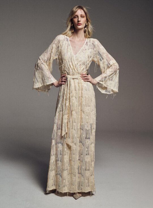 Μακρύ φόρεμα boho-chic με ανοιχτό ντεκολτέ BE YOU Διαθέτει διάφανη δαντελένια υφή και έντονα κρόσσια που δίνουν υπέροχη κίνηση. Μακριά φαρδιά μανίκια καμπάνα. Ζώνη ίδιου υφάσματος στη μέση. Το ύφασμα και οι λαμπερές λεπτομέρειες του σχεδίου το κάνουν ιδανικό για ιδιαίτερες περιστάσεις Σύνθεση:100%POL