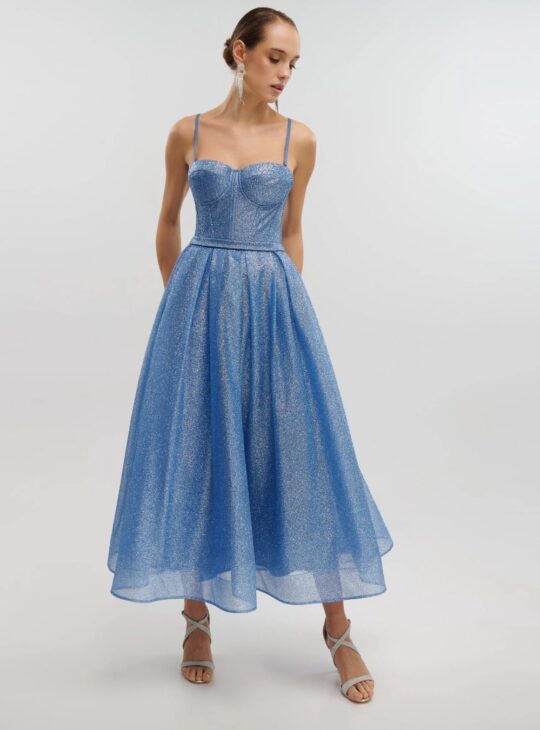 Girly, παραμυθένιο και άκρως λαμπερό τούλινο midi φόρεμα με glitter σε όλη του την επιφάνεια, στην απόχρωση του indigo . Το επάνω μέρος είναι κορσές που δένει χιαστί στην πλάτη. Διαθέτει τιράντες και cups. Η φούστα του είναι σε Άλφα γραμμή και κλείνει πίσω στη μέση με φερμουάρ.